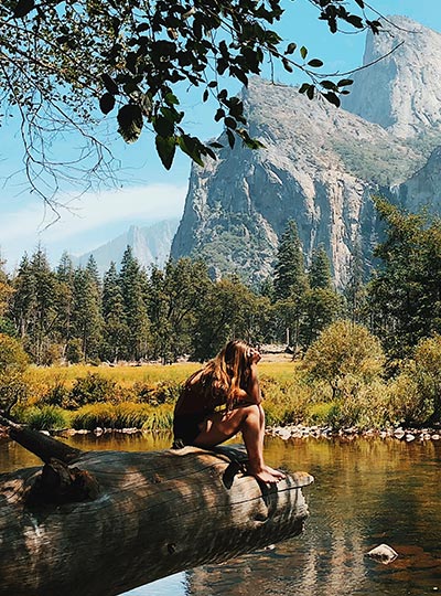 Adéla sedí na kameni a hledí do krajiny